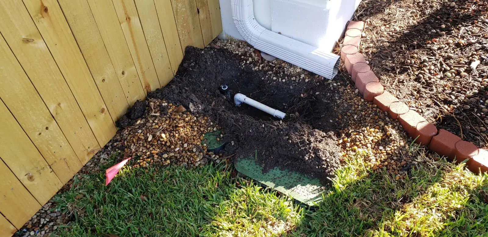 New irrigation riser installed along a fence line in fresh soil